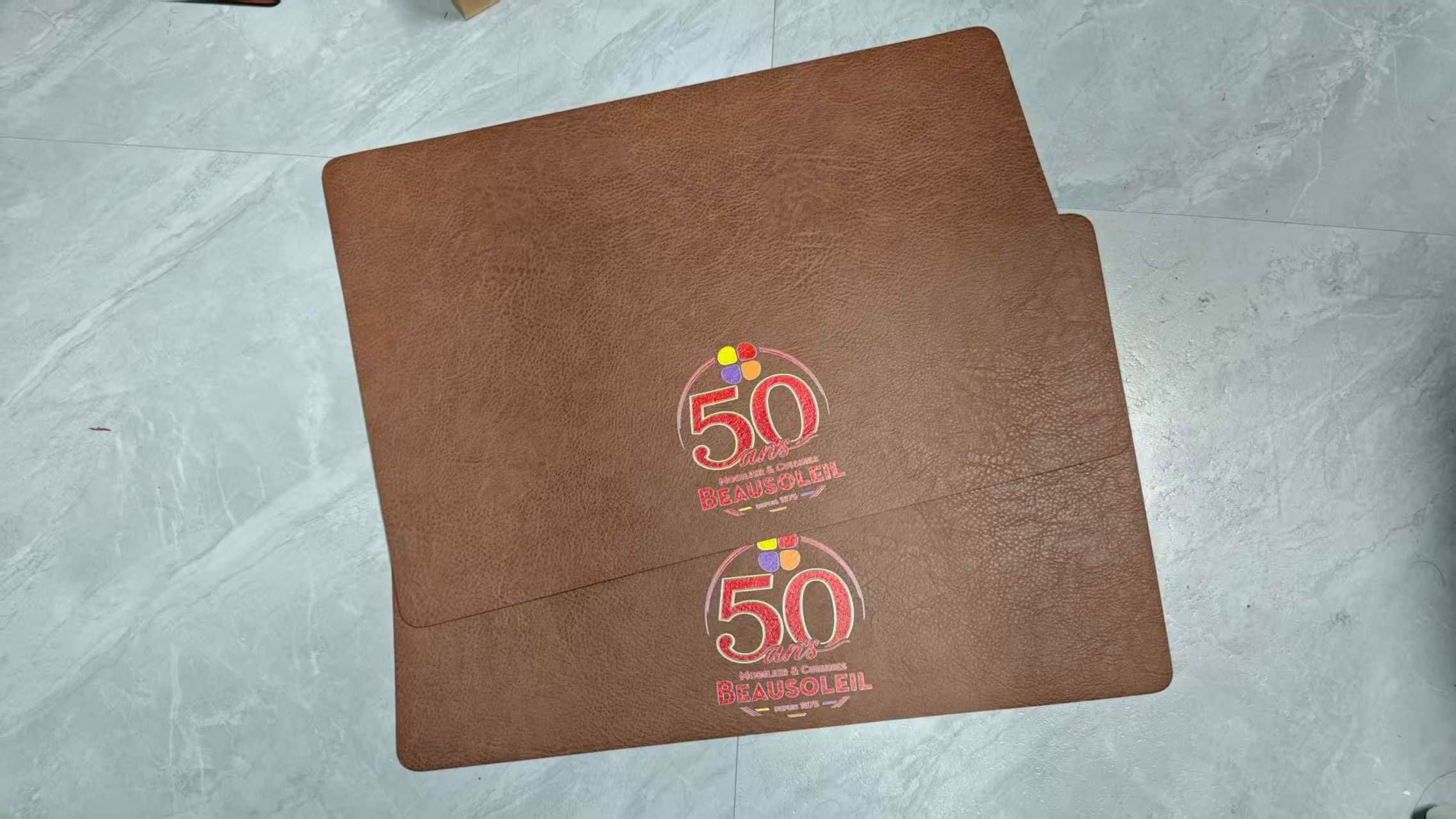 Two real brown PU leather placemats with matching customer logo artwork